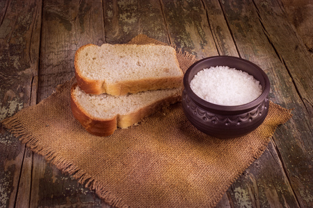 bread, salt, on a background of  brown boards and burlapの写真素材