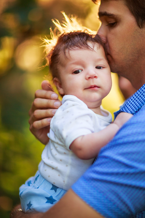 Dad with a shaggy baby boy in his arms, close-up, summer photos outdoorの写真素材