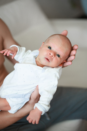 dad with newborn baby at home, light backgroundの写真素材