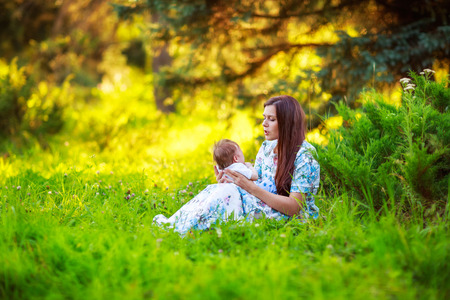 Mother kisses baby son, close-up, summer photos outdoorの写真素材