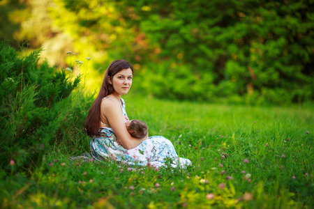 Mom feeds the baby, breastfeeding, summer photos outdoor, infant feedingの写真素材