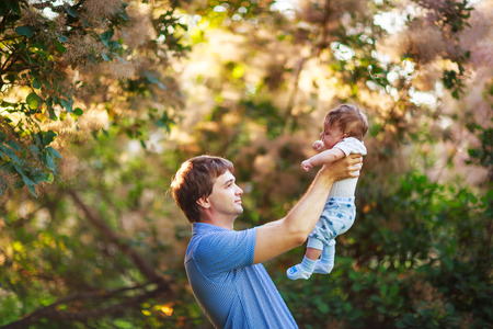 Dad with a baby boy in his arms, close-up, summer photos outdoorの写真素材