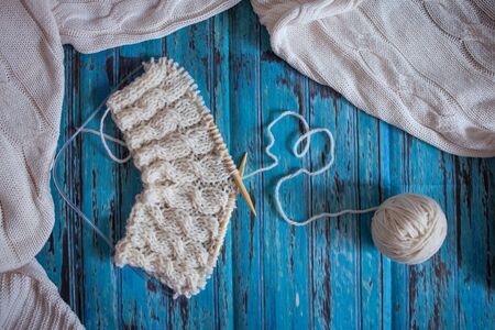 knitting with white woolen thread, knitting with braids on a blue backgroundの写真素材