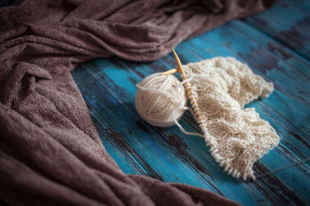 knitting with white woolen thread, knitting with braids on a blue backgroundの写真素材