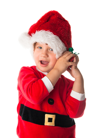 Smiling funny child girl in Santa red hat holding Christmas gift in hands. Christmas concept. play with giftの写真素材
