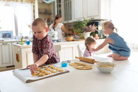 children with her mother preparing cookiesの写真素材
