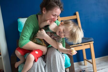 portrait of  young mother with her baby at home, living a real interior , Mom and son embrace