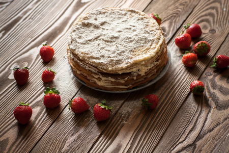 Cake of the pancakes, cake with strawberry top view of a dark brown wooden background, rustic style