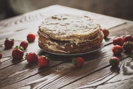 Cake of the pancakes, cake with strawberry top view of a dark brown wooden background, rustic style