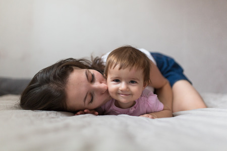 happy loving family. mother playing with her baby in the bedroom. Cosy house, lifestyle, selective focus, toningの写真素材