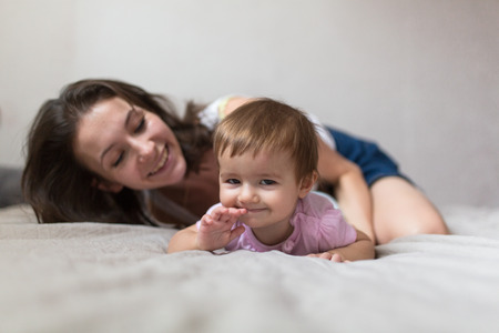 happy loving family. mother playing with her baby in the bedroom. Cosy house, lifestyle, selective focus, toningの写真素材