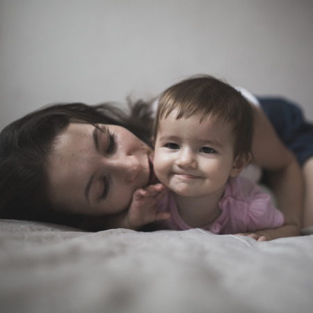 happy loving family. mother playing with her baby in the bedroom. Cosy house, lifestyle, selective focus, toningの写真素材