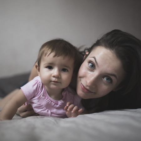 happy loving family. mother playing with her baby in the bedroom. Cosy house, lifestyle, selective focus, toningの写真素材