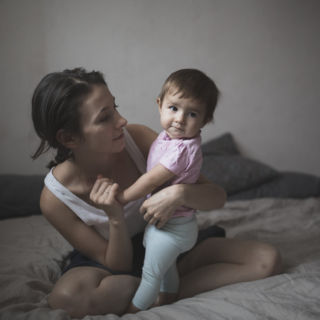 happy loving family. mother playing with her baby in the bedroom. Cosy house, lifestyle, selective focus, toningの写真素材