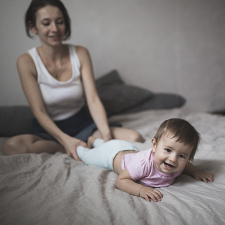 happy loving family. mother playing with her baby in the bedroom. Cosy house, lifestyle, selective focus, toningの写真素材