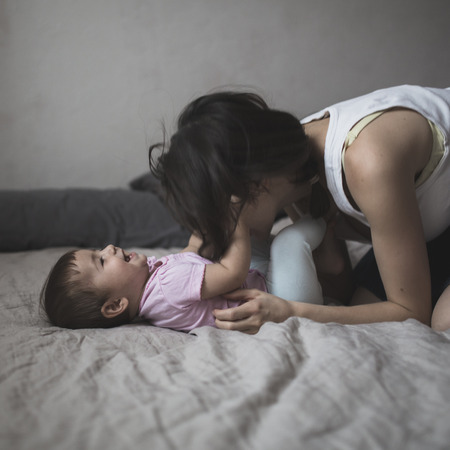 happy loving family. mother playing with her baby in the bedroom. Cosy house, lifestyle, selective focus, toningの写真素材