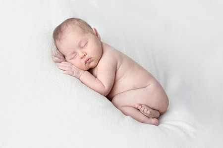 newborn sleeping on a light background, close-up, lifestyle, real life, the concept of purity and innocence, copyspaceの写真素材