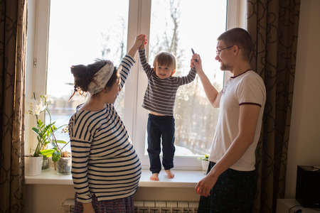 happy family with son kid toddler playing around  window, home real interior, lifestyle, toning,...