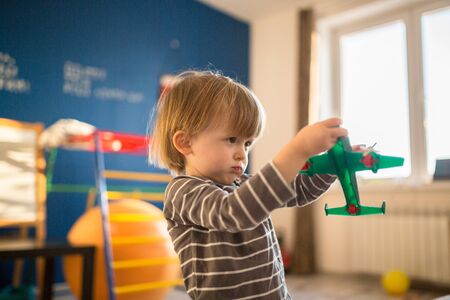Toddler boy playing with the Airplane, the real interior, soft focus, light toning, concept and childhood dreamsの写真素材