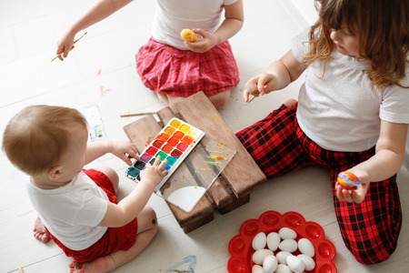 sibling children paint eggs with watercolors, and the concept of Easter children's creativityの写真素材