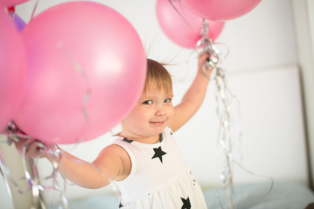 Funny girl child Toddler in dress with stars with balloons, children's holidayの写真素材