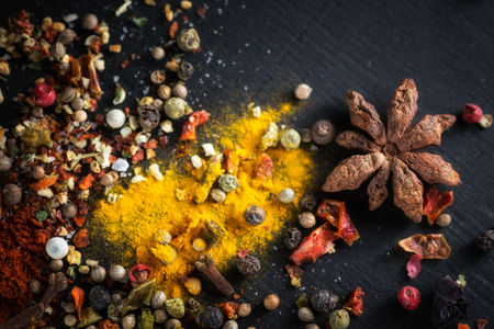 Cardamom, anise. Different colorful seasonings close-up against a black chalk boardの写真素材