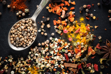 Cardamom, anise. Different colorful seasonings close-up against a black chalk board