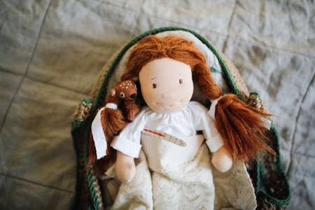 Cute waldorf doll with with a thermometer under the armの写真素材