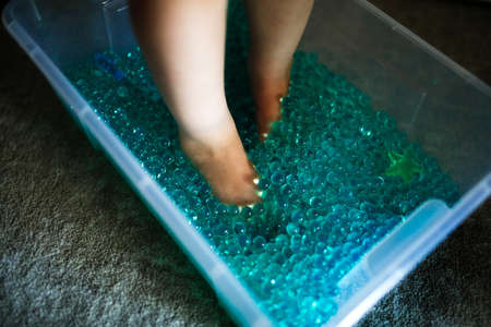 Close up of a child's feet in a plastic box