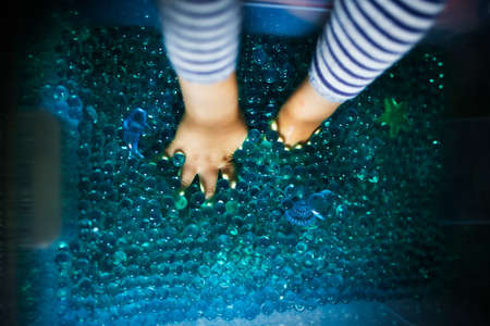 Woman's feet in the water with bubbles. Selective focus.