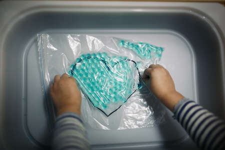 Hands of a child in protective gloves cleaning.