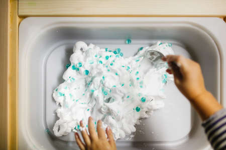 A child washes clothes in a washing machine. Selective focus.の写真素材