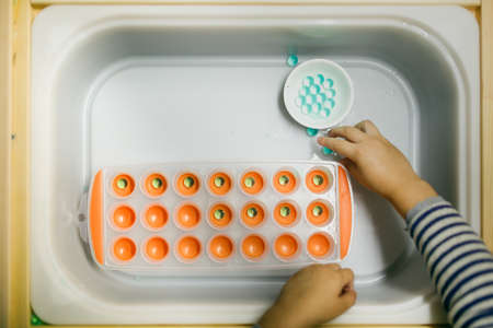 A child plays with a multicolored plastic toy.の写真素材