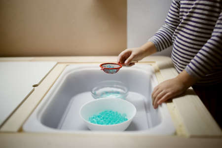 Close-up of a child's hands washing in the kitchen.