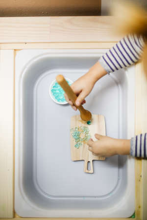 Little girl in the kitchen washing dishes.の写真素材
