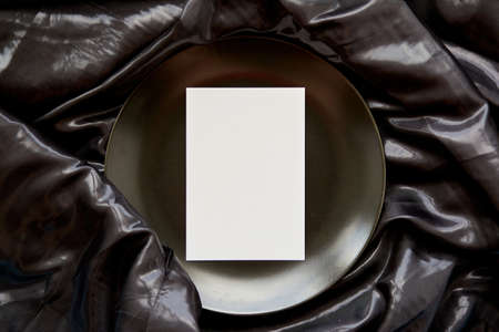 inimalistic flat lay: stationery card on black plate. Top view mock up. Birthday card or advertising place. High quality photoの写真素材