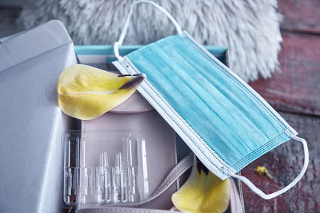 Medicine box with protective mask, capsules and decorative petals of flowers. High quality photo