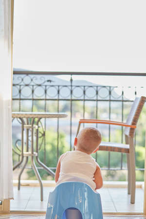 Child is sitting on a potty with a beautiful mountain view. High quality photoの写真素材