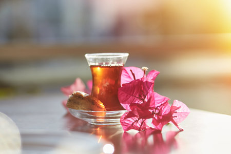 Turkish delight and traditional glass of turkish tea with bougainvillea flowers. Romantic dinner concept. Relaxing, calming drink Travel Turkey concept. Bright relaxing drink. High quality photoの写真素材