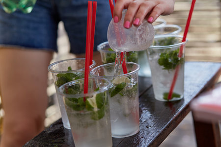 Young woman at a bachelorette party makes a mojito cocktail for the company. Preparation instructions. Step 2. High quality photoの写真素材