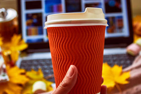 Paper orange coffee cup mock up close up. Autumn atmosphere. Vertical photo. High quality photoの写真素材