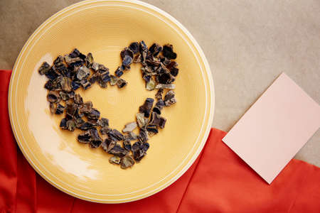 Carob in shape of heart symbol of coffee alternative - natural product on the plate. Organic...
