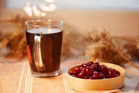 Natural healthy calming drink with dogwood berry. Autumn healthy food. Pastel colors with copy space. Healthy organic food. Vitamin tea. Home coziness, decorations table. High quality photoの写真素材
