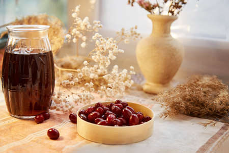 Natural healthy calming drink with dogwood berry. Autumn healthy food. Pastel colors with copy space. Healthy organic food. Vitamin tea. Home coziness, decorations table. High quality photoの写真素材