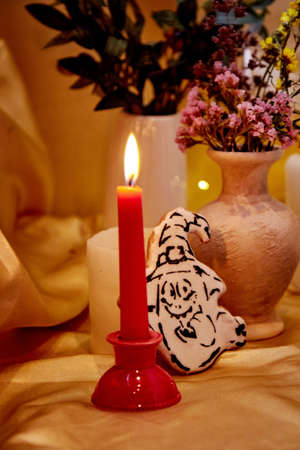 Creative Halloween decorations atmosphere. Halloween holidays with candles, homemade cookies of...