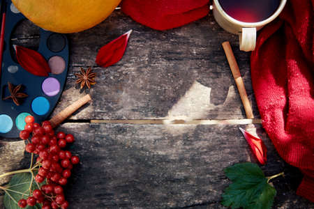 Autumn aesthetic still life: fruits, vegetables and bright paints with a cinnamon sticks, viburnum, flower petals and cup of tea. Thanksgiving Day concept. Autumn flat lay with cozy modern shadows.の写真素材
