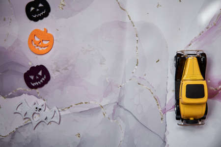 Halloween decors with felted pumpkins and yellow retro car. Happy Halloween concept. Copy space. Top...