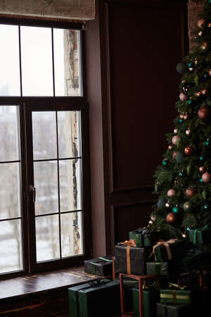 Christmas tree in home interior near big window in high key. Presents box near the decorated tree. High quality photoの写真素材