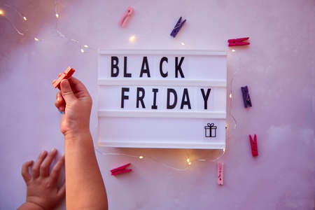 Signboard with text Black Friday and present. Baby curiosity for shopping with clothespins. Top view. High quality photoの写真素材