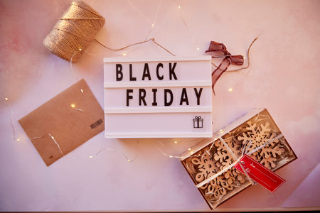 Signboard with text Black Friday and decorations. Online shopping concept. Buying presents for Christmas. Safe home shopping. Cozy home. Christmas preparations.Top view. High quality photoの写真素材